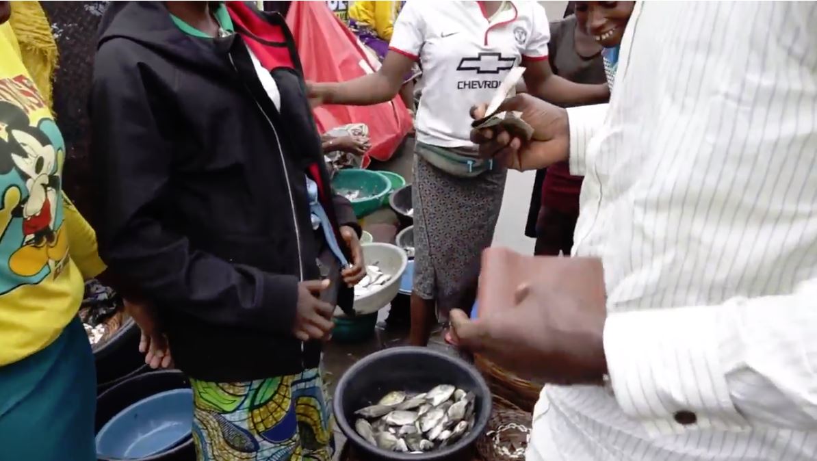 Man buying fish at a fish market in Africa 